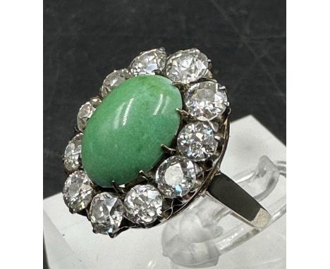 An outstanding jade and diamond ring a central jade stone surrounded by eleven diamonds (approximately 3cts) set on a white g