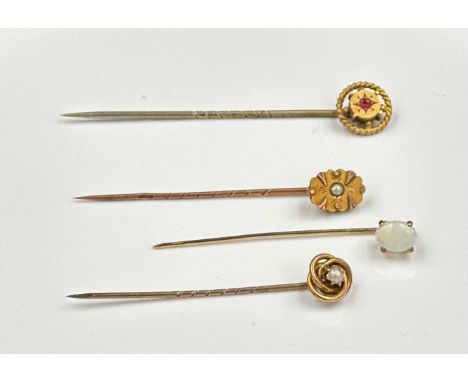 A selection of four lapel pins, three gold including opal and pearl.