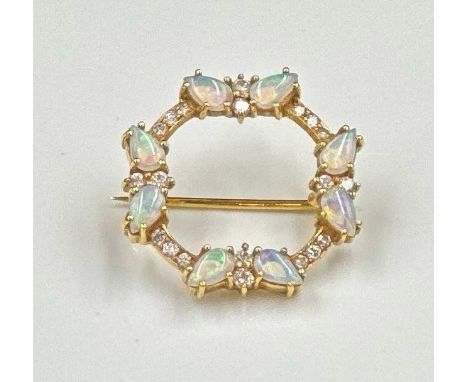 A circular brooch with opal and diamonds, set in 18ct yellow gold, approximately 22mm in diameter and 4.9cm