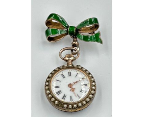 A green enamel and silver pocket watch with Fleur De Lis decoration along with seed peals around the bezel, supported by a gr