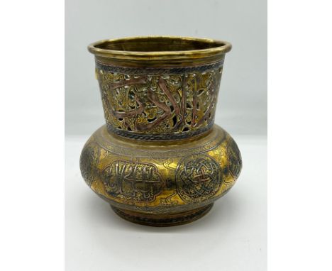 An Islamic vase, the brass vessel is inlaid with copper and Arabic calligraphy (H17cm Dia15cm)