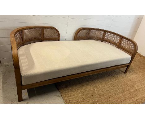 A Nest daybed with teak curved frame and cane sides (H69cm W212cm D98cm)