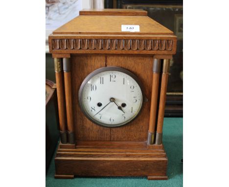 An oak cased striking mantel clock
