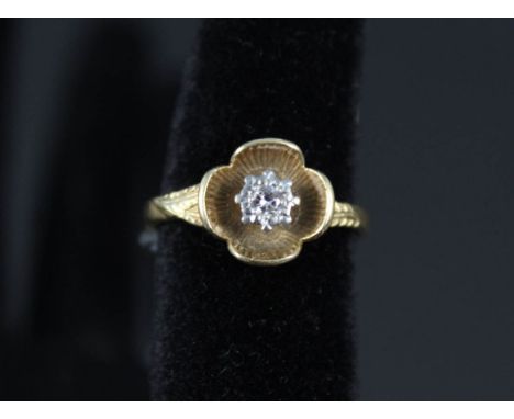 An 18ct gold solitaire diamond ring in flower setting, size L