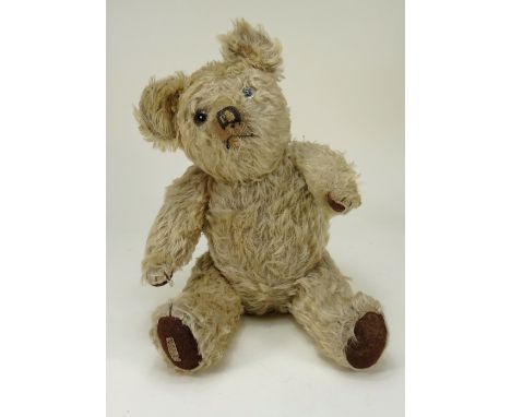 A scarce Jaeger Teddy bear, English 1930s, the light brown mohair bear with clear glass eyes, upturned clipped muzzle with bl