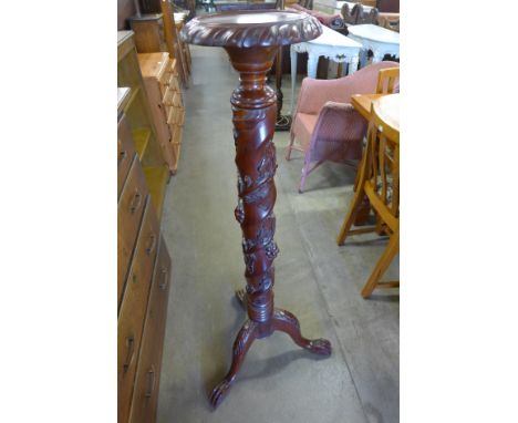 A carved mahogany jardiniere stand