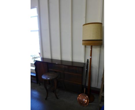 A mahogany bookcase carved occasional table, teak standard lamp and a copper warming pan