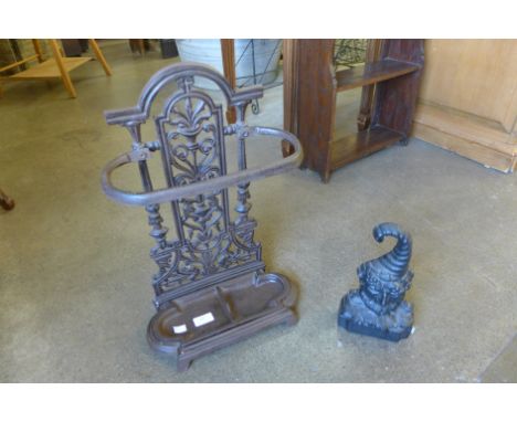 A cast iron stick stand and a cast iron figural doorstop of Bacchus