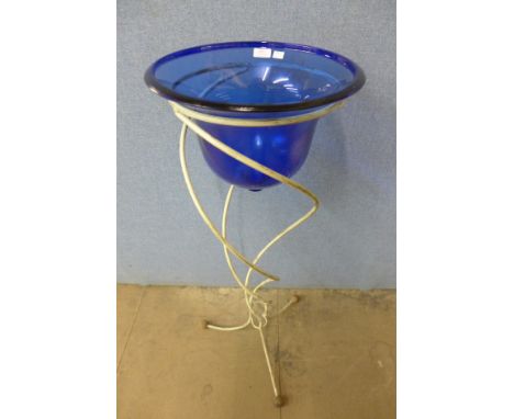 A blue glass bowl on wrought iron stand