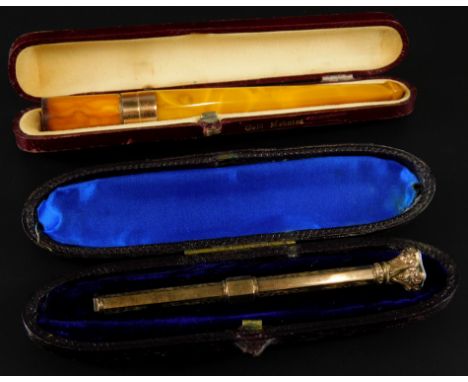 Two trinket items, comprising an amber cheroot holder with yellow metal rim, and a gilt metal propelling pencil, with floral 