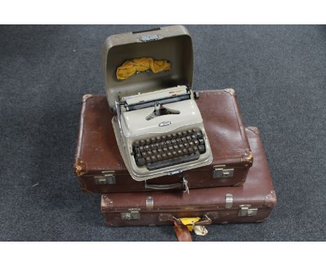 Two vintage leather suitcases and a Triumph typewriter