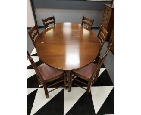 A Reprodux oak gate leg table and six ladder back dining chairs. 