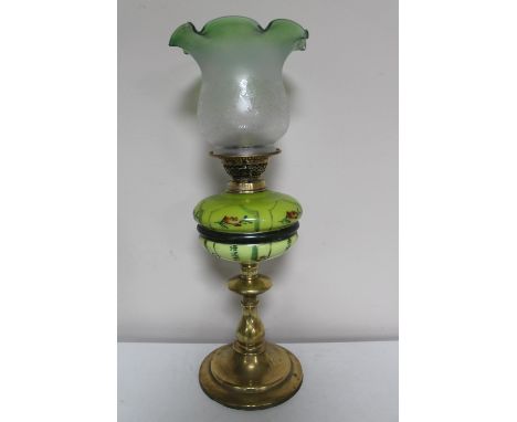 A brass oil lamp with etched shade and painted reservoir CONDITION REPORT: Several small nicks to the base of the glass shade