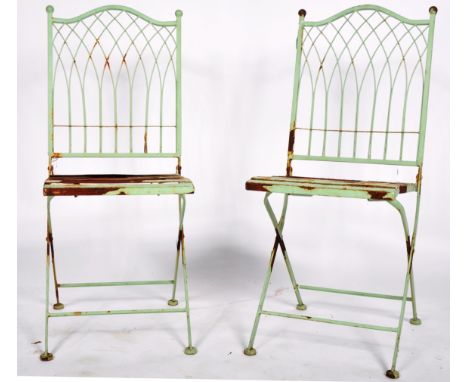 A matching pair of vintage 20th Century French painted metal cafe / garden folding chairs / dining chairs having decorative s