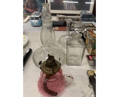 A GROUP OF VINTAGE DECANTERS AND A CRANBERRY GLASS CONVERTED OIL LAMP JUG 