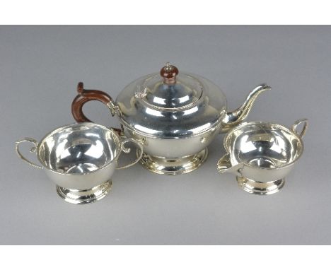 A GEORGE V SILVER THREE PIECE CIRCULAR TEA SERVICE, brown bakelite fitments, 'C' scroll handles, stepped circular foot, maker