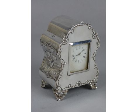 A LATE VICTORIAN/EDWARDIAN SILVER BOUDOIR CLOCK, the front with foliate scroll outline, the sides with embossed Reynolds Ange