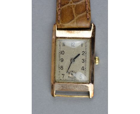 AN EARLY TO MID 20TH CENTURY GENTS 9CT WRISTWATCH, rectangular case to a brown leather strap, silvered dial, unsigned with bl