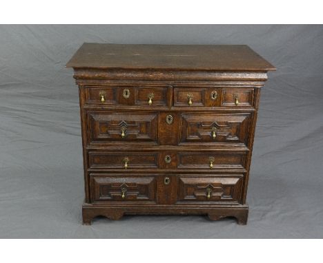 AN EARLY 18TH CENTURY AND LATER OAK CHEST OF DRAWERS, replacement top over two short and three long drawers with geometric fi