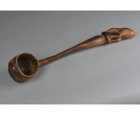 A CARVED TREEN LADLE, with Kiwi bird finial, the ladle bowl exterior carved as a head, length approximately 47cm