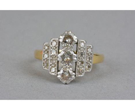 A LATE 20TH CENTURY DIAMOND DRESS RING, centring on three modern round brilliant cut diamonds, flanked by two stepped rows of