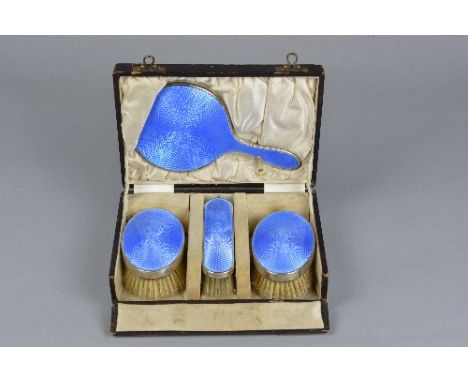 A CASED GEORGE V SILVER AND BLUE ENAMEL CHILD'S DRESSING TABLE SET, engine turned decoration, maker F.G. Rose, Birmingham 192