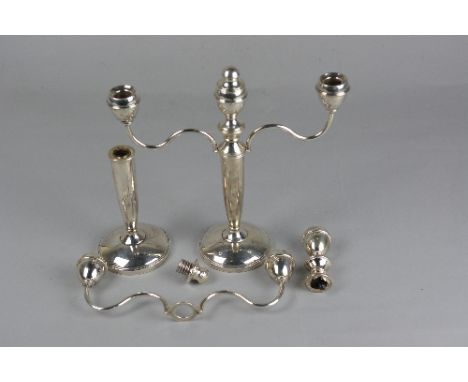 A PAIR OF ELIZABETH II SILVER THREE BRANCH CANDELABRA, one defective, the cylindrical column with screw fitting base so centr