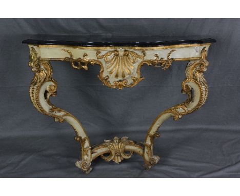 A 19TH CENTURY BAROQUE STYLE GESSO AND GILTWOOD CONSOLE TABLE, the later ebonised faux black marble wood top of serpentine ou