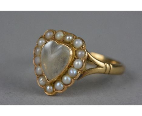 A LATE VICTORIAN MOONSTONE AND SEED PEARL HEART RING, a heart shaped cabochon moonstone contained within a border of seed pea