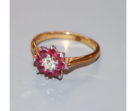 A modern 18ct gold, ruby and diamond flowerhead cluster ring, size O.