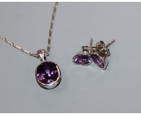 A modern white metal and amethyst suite of jewellery, comprising a pendant on 750 chain and a pair of 750 set earstuds.