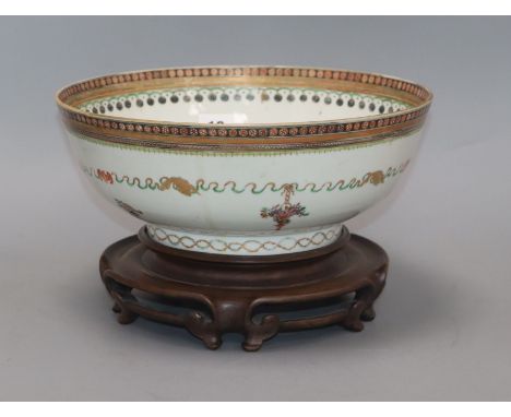 A late 18th century Chinese export polychrome bowl, decorated with a band of ribbon and flowers in baskets, with hardwood sta