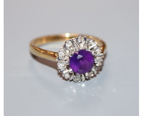 A modern 18ct gold, amethyst and illusion set diamond circular cluster ring, size O.