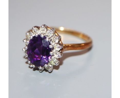 A modern 18ct gold, amethyst and diamond oval cluster ring, size S/T.