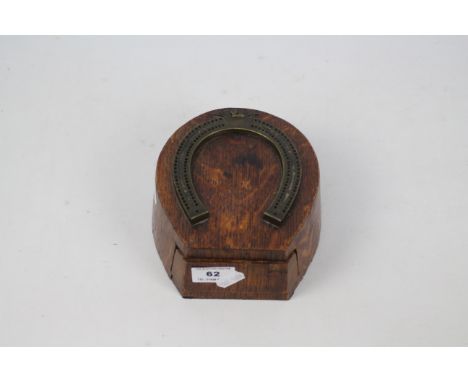 A late 19th or early 20th century cribbage scorer in the form of a horseshoe, mounted to an oak box with spring loaded frieze