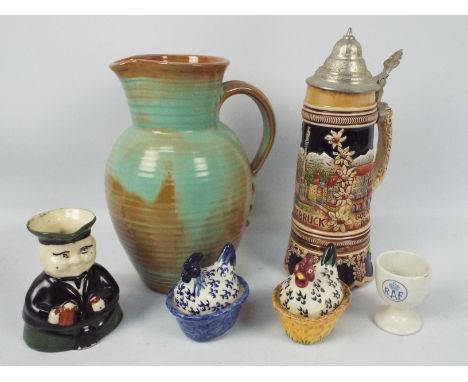 A group of ceramics to include a Prinknash Pottery jug (25 cm height), lidded stein, character jug, Ashworth Bros eggcup with