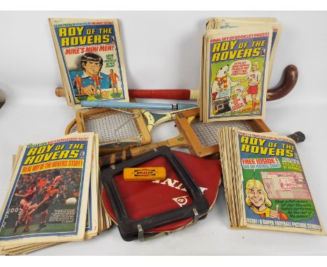 Vintage sporting equipment including tennis rackets and hockey stick and a collection of vintage Roy Of The Rovers magazines.