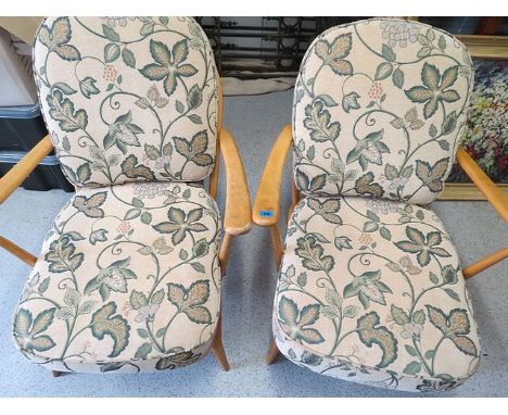 A pair of Ercol light beech open armchairs with loose cushions