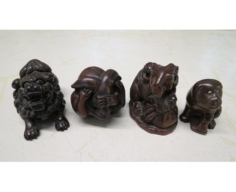Four Chinese carved hardwood netsuke fashioned as a dog of foe, a dog, a goat and a rabbit