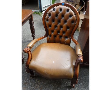 A Victorian style leather deep button back salon chair with serpentine fronted, overstuffed seat on French cabriole style fro