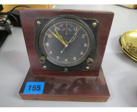 An early 20th century car clock on a mahogany stand, the rear signed A M