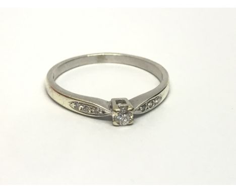 A 9ct white gold solitaire diamond ring with further diamonds to the shoulders, approx 2g and approx size O.