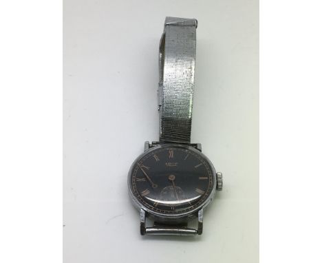 A vintage Editia Prima manual wind watch with black dial and replacement strap. Watch has a loose hand.