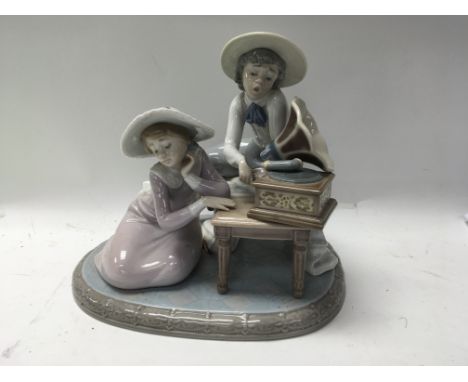 A Lladro figure group in the form of a couple with gramophone.