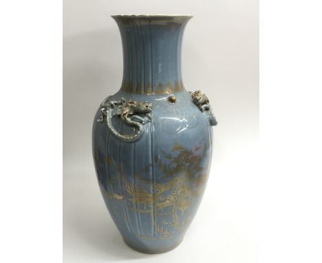 A large late 19th Century vase with giltwork landscape decoration on a light blue ground and with applied dragon decoration, 