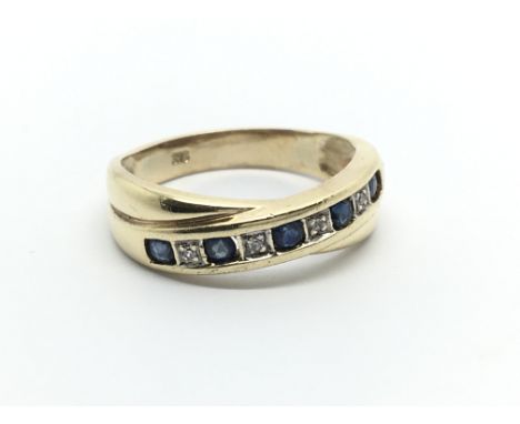 A 9carat gold ring set with alternating diamond and blue sapphire. Ring size N-O