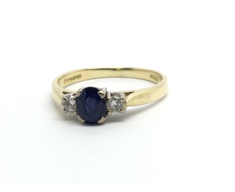 An 18ct gold ring set with a sapphire and two diamonds, approx 2.2g and approx size I-J.