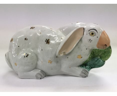 An interesting late 19th Century Continental ceramic rabbit figure, slight damage to one ear, approx length 24cm.