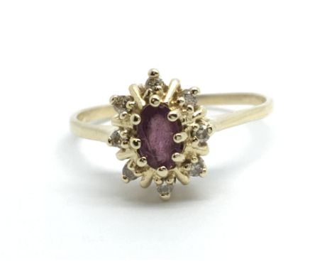 A 9ct gold ring set with a central ruby surrounded by eight small diamonds, approx 2g and approx size K-L.