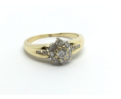 An 18ct gold nine stone diamond ring with a further four diamonds to the shoulders, approx.25ct, approx 3.9g and approx size 